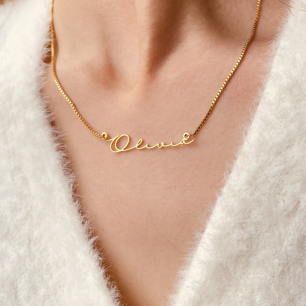 Naamketting in goud met de naam Olivia in schrijfletters, gedragen op de hals