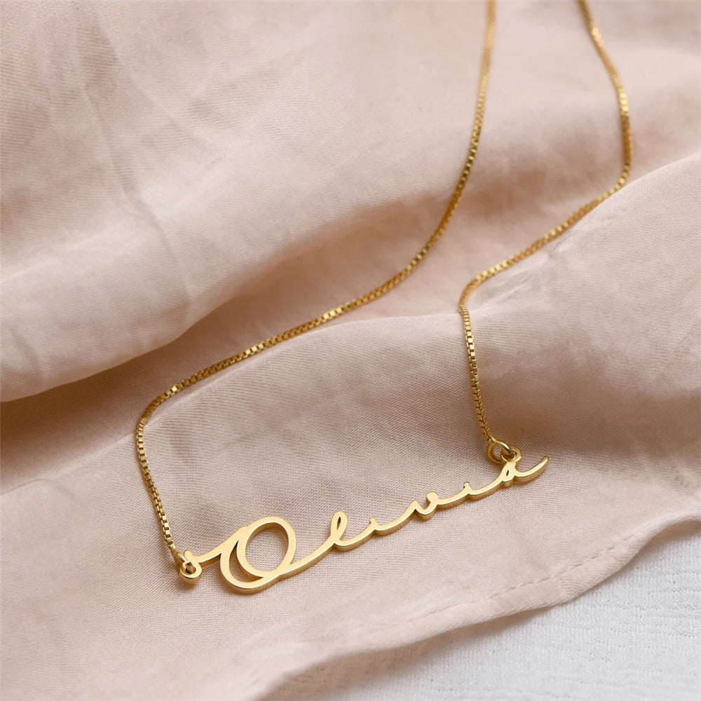 Gouden naamketting met de naam Olivia op roze stof (voorbeeldnaam)