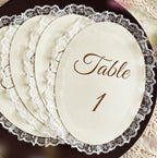 Stapel ovale tafelnummerkaarten met kantrand en het opschrift Table 1 in bruin schrift